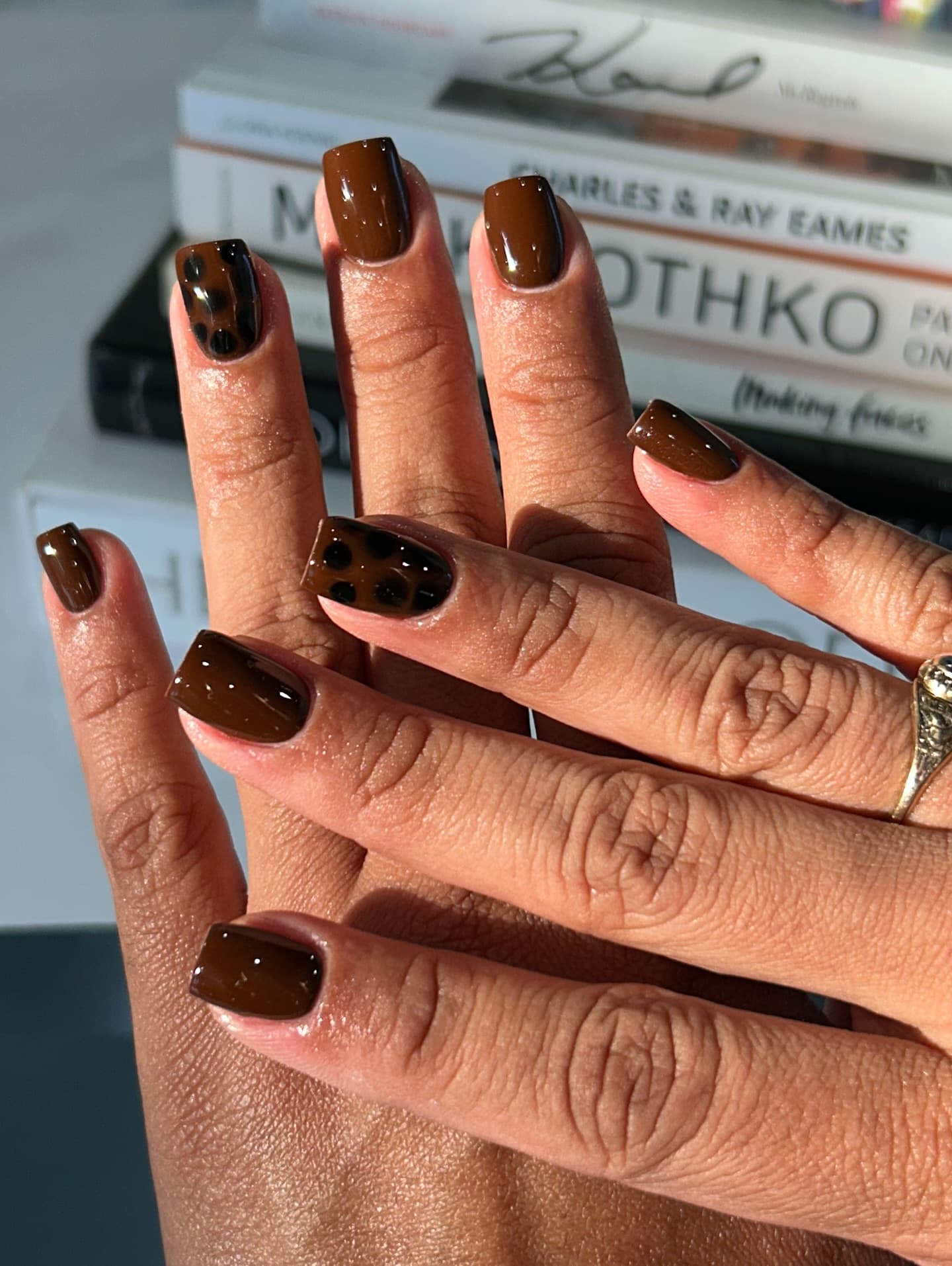 Glossy brown nail art with a tortoiseshell accent